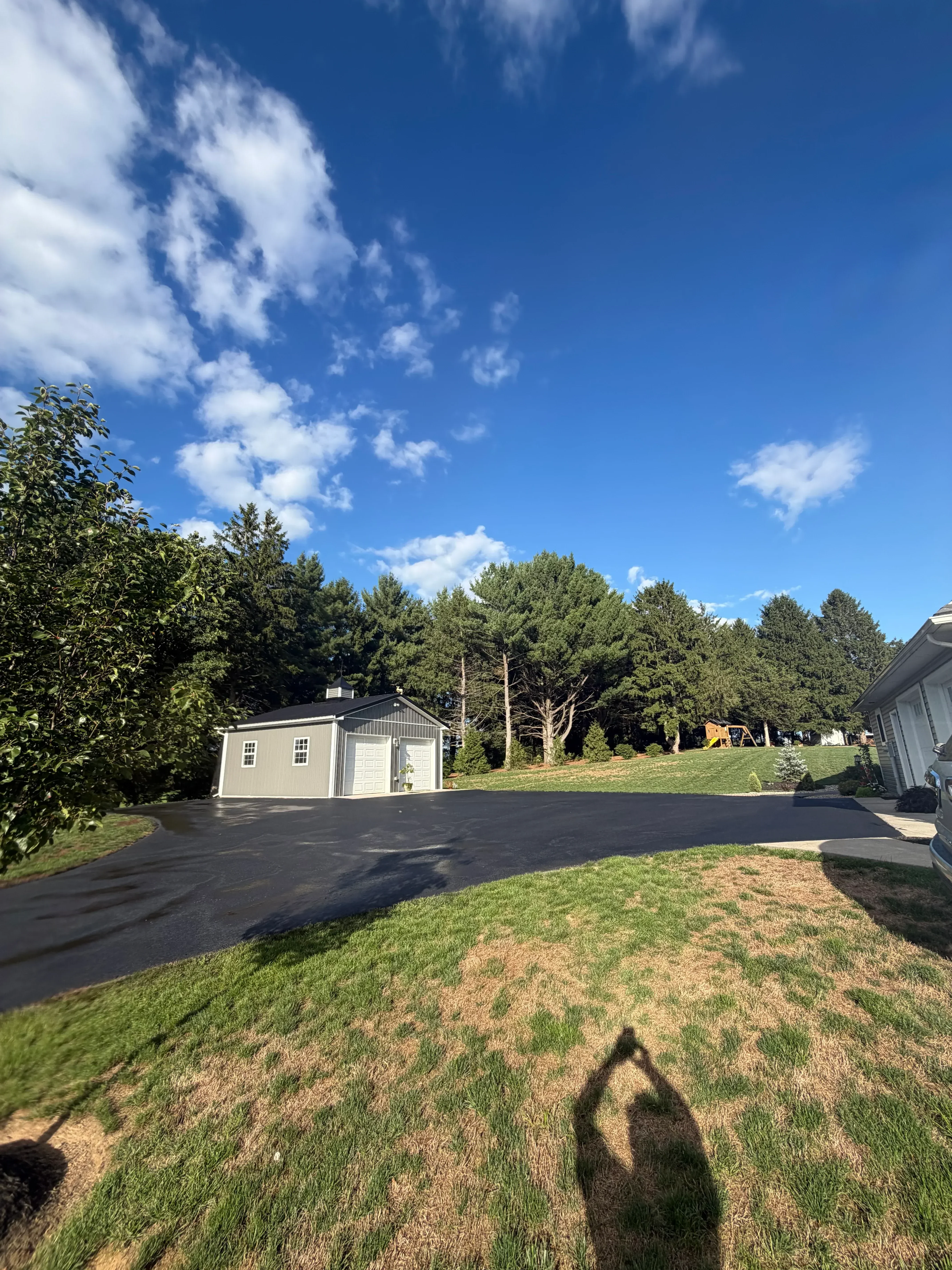 Newly paved residential asphalt driveway with dark surface and clean edges