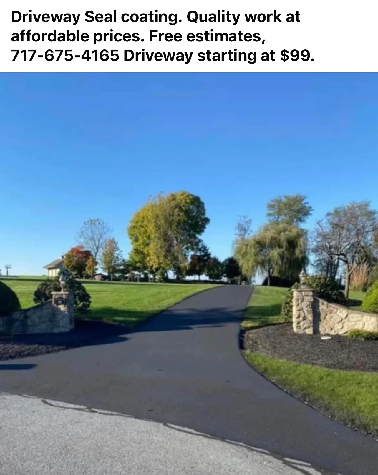Freshly sealed asphalt driveway with dark finish and clean edges bordering stone pillars