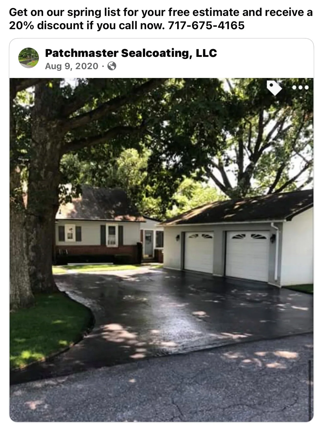 Sealed asphalt driveway with dark finish in front of two-car garage and brick home