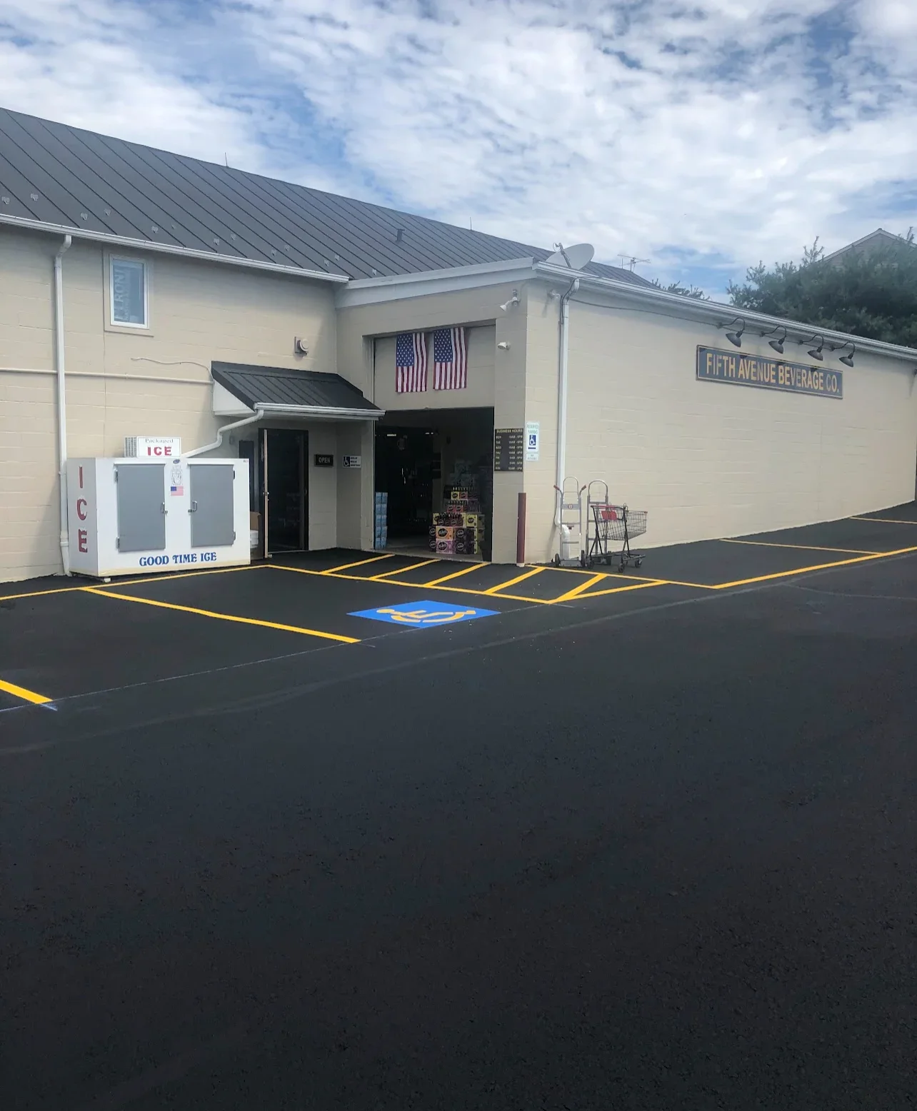 Newly sealed asphalt parking lot with bright yellow striping and blue handicap symbol marking